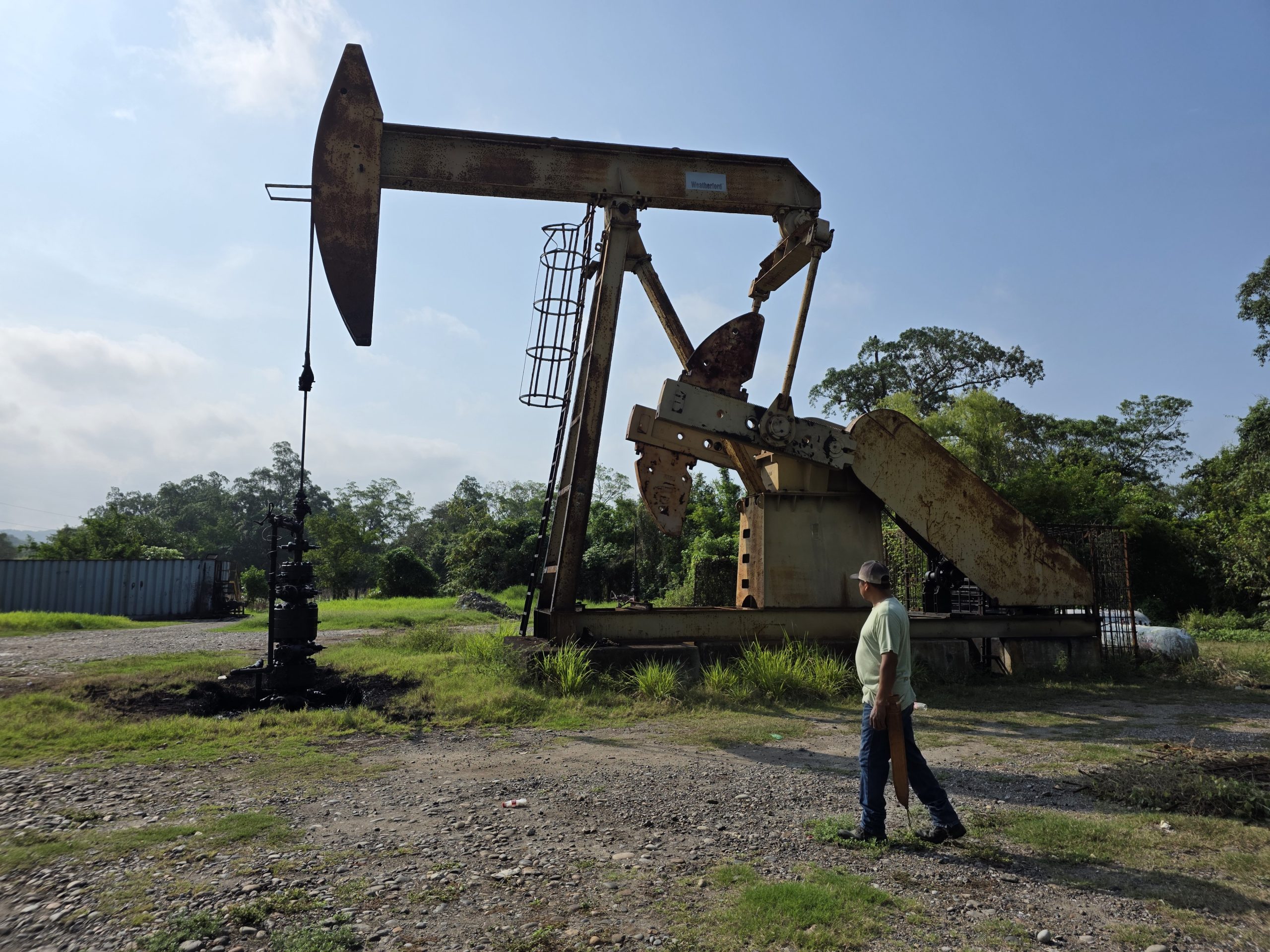 man walking near oil pumping unit