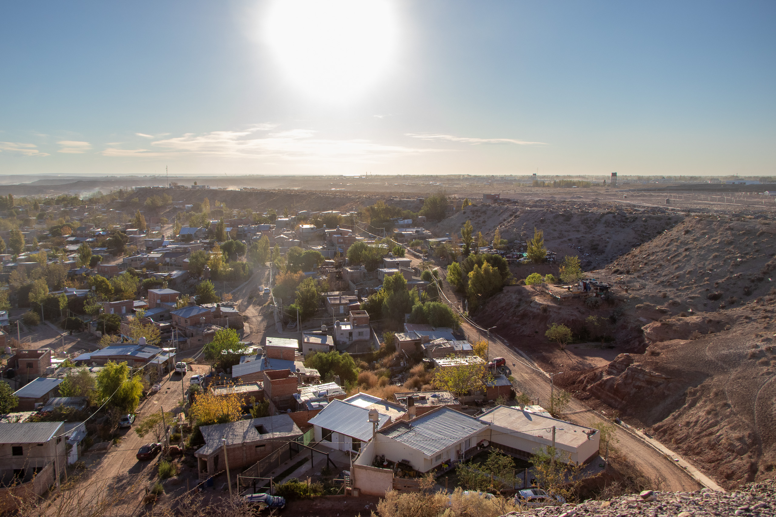 Barrio de casas bajas con montañas de tierra alrededor