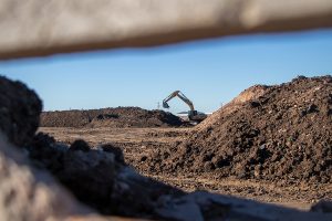 Una máquina excavadora y montañas de residuos al aire libre