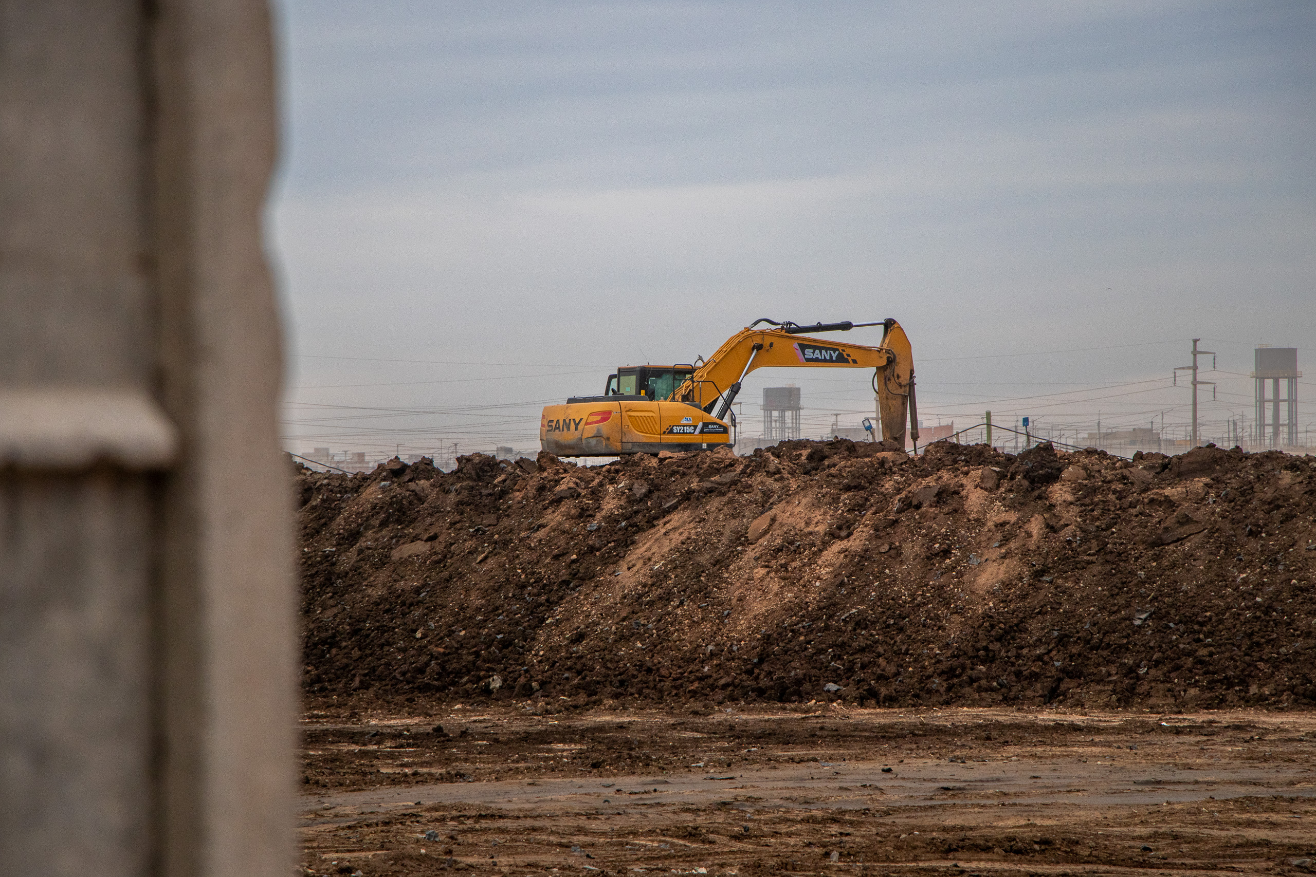 excavadora sobre un gran montículo de tierra