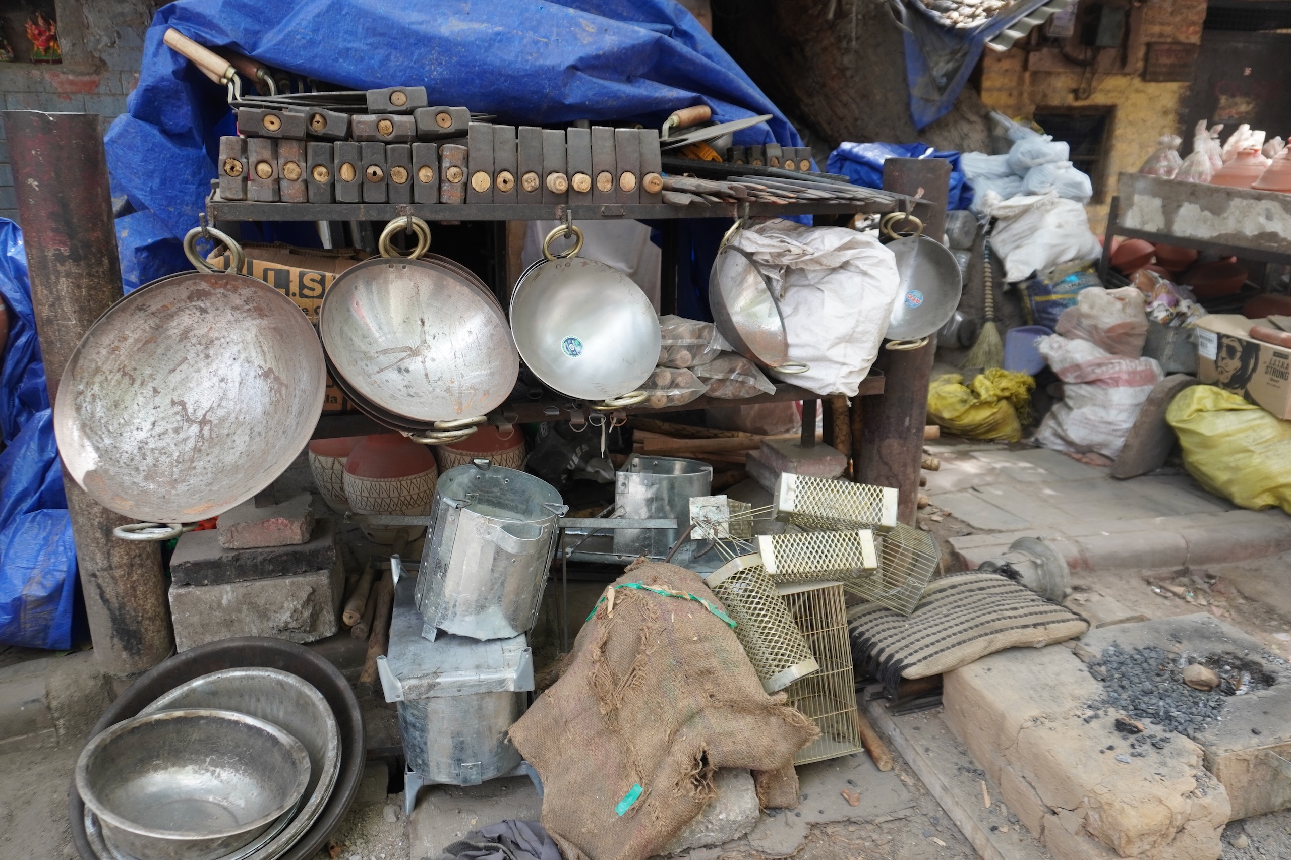 A stack of various metal pots and pans at a roadside shop