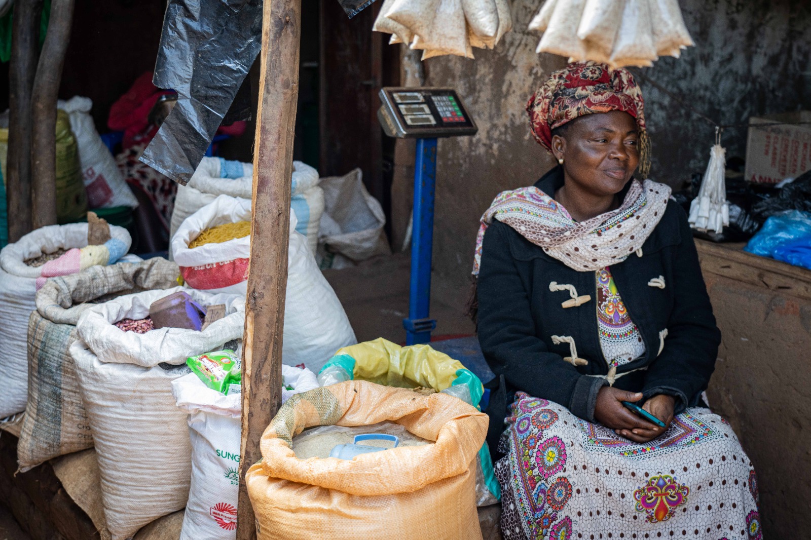 A woman sits in front of several bags of food