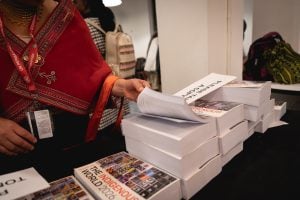 person flipping pages of book on top of stack