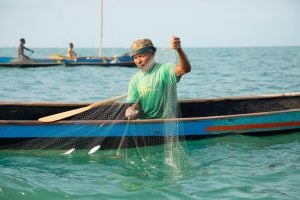 Malagasy fisherman on wooden pirogue boat