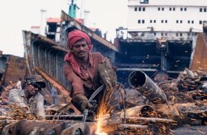 men dismantling large pieces of steel