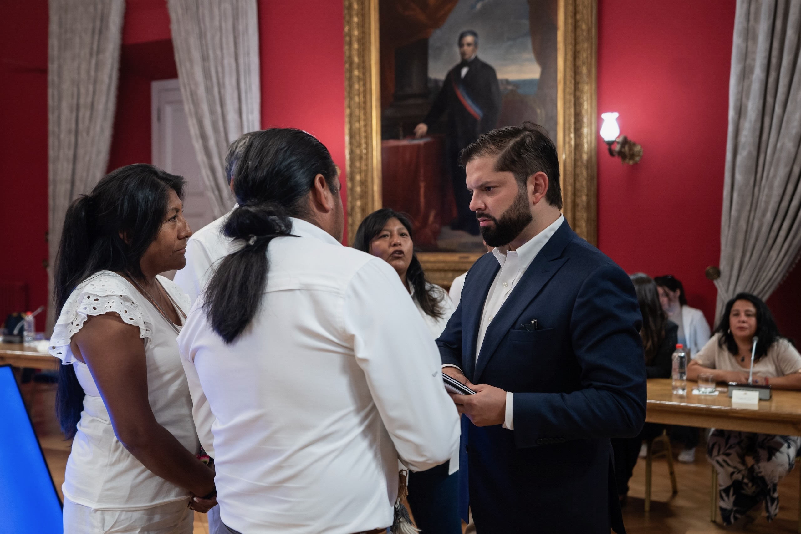 A formal meeting with a group of people discussing important matters in a historic setting