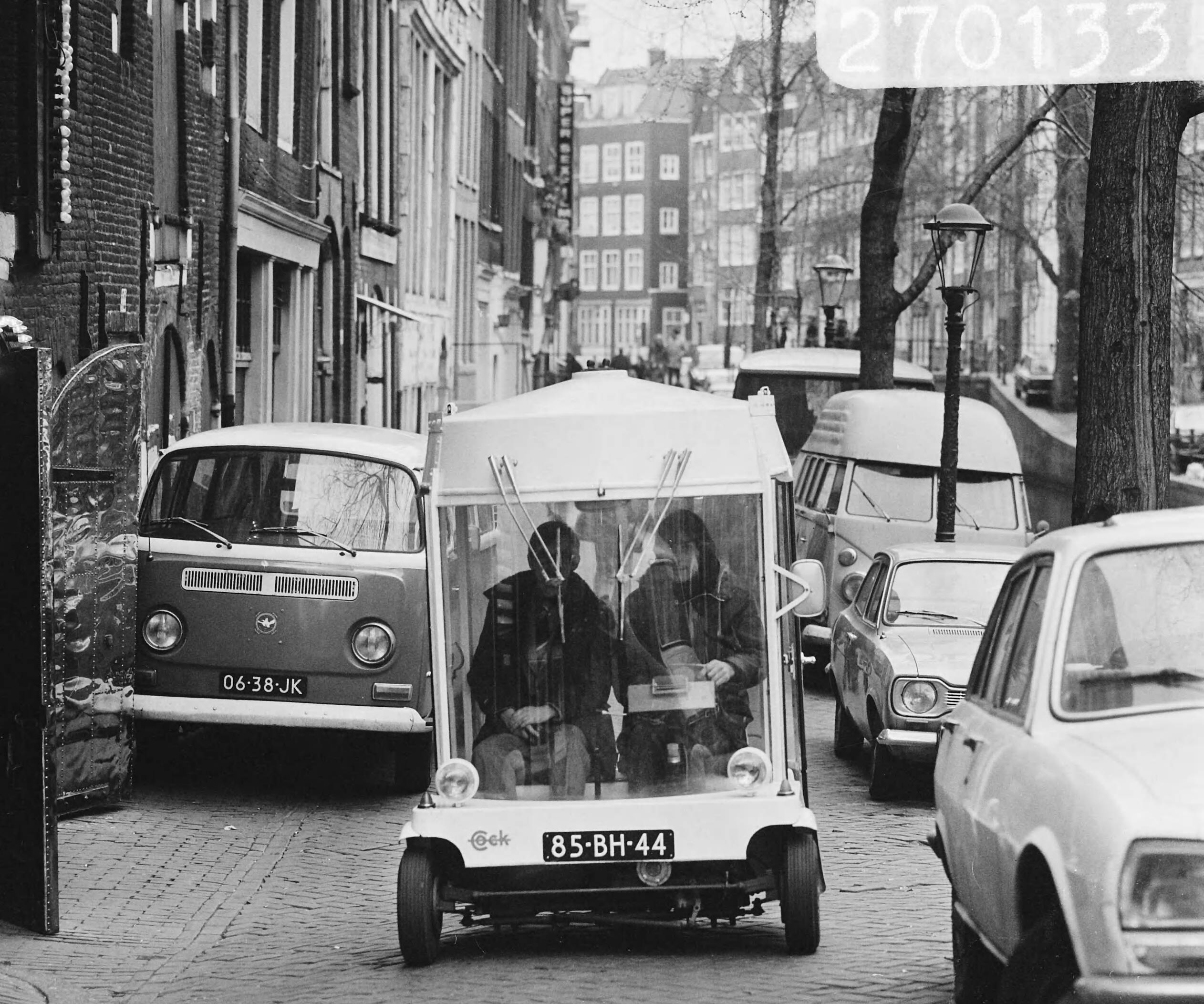 two men sit inside a car with a tent mounted on the top