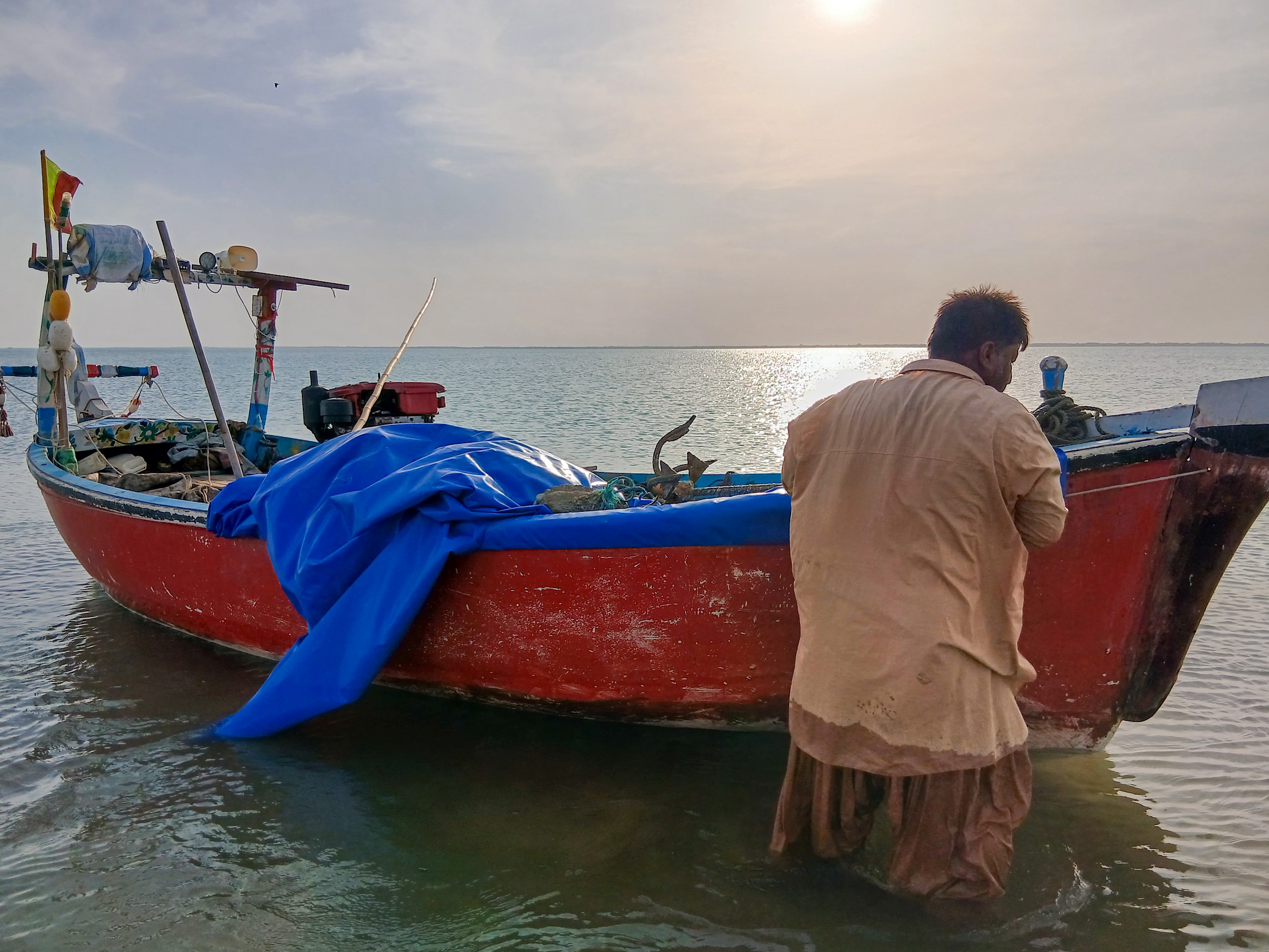 <p>A local fisher tends to his boat in Gwadar, Pakistan, a fishing community that has gradually declined following the installation of a deep-sea port, rapid development and competition from trawlers (Image: Muhammad Akbar Notezai)</p>