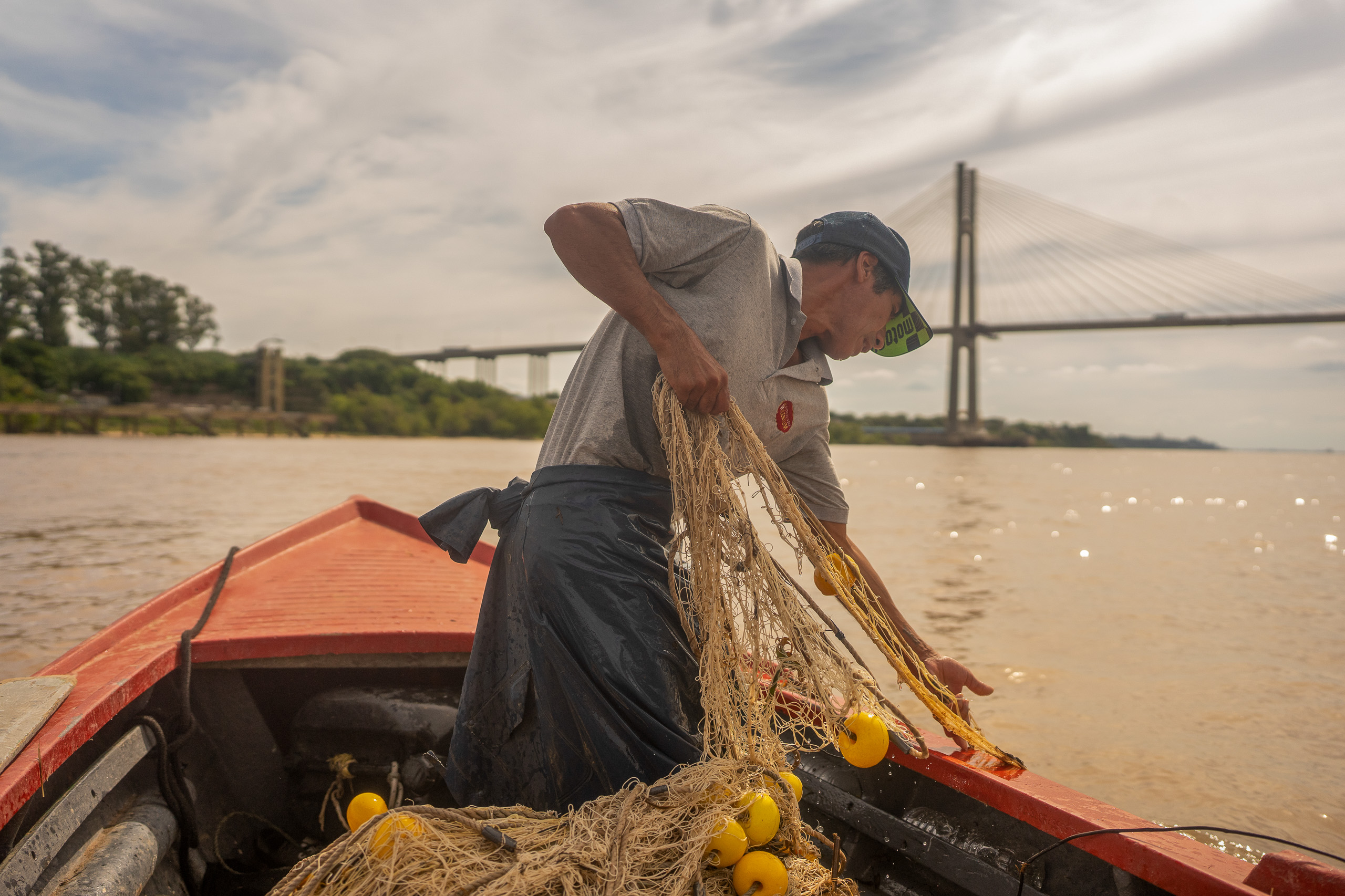Un hombre en un barco preparando una red de pesca