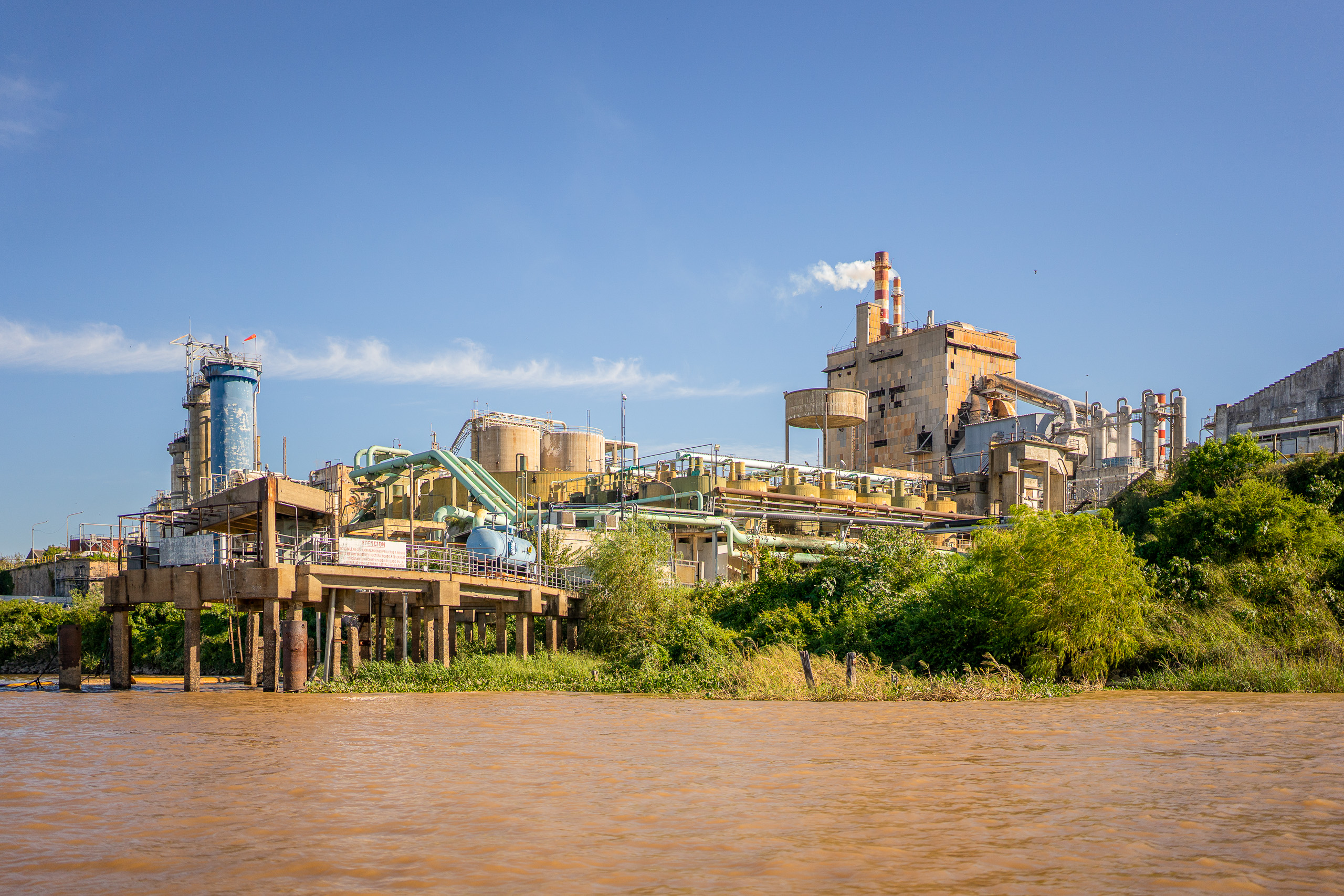 Fábrica industrial a orillas del río con una chimenea