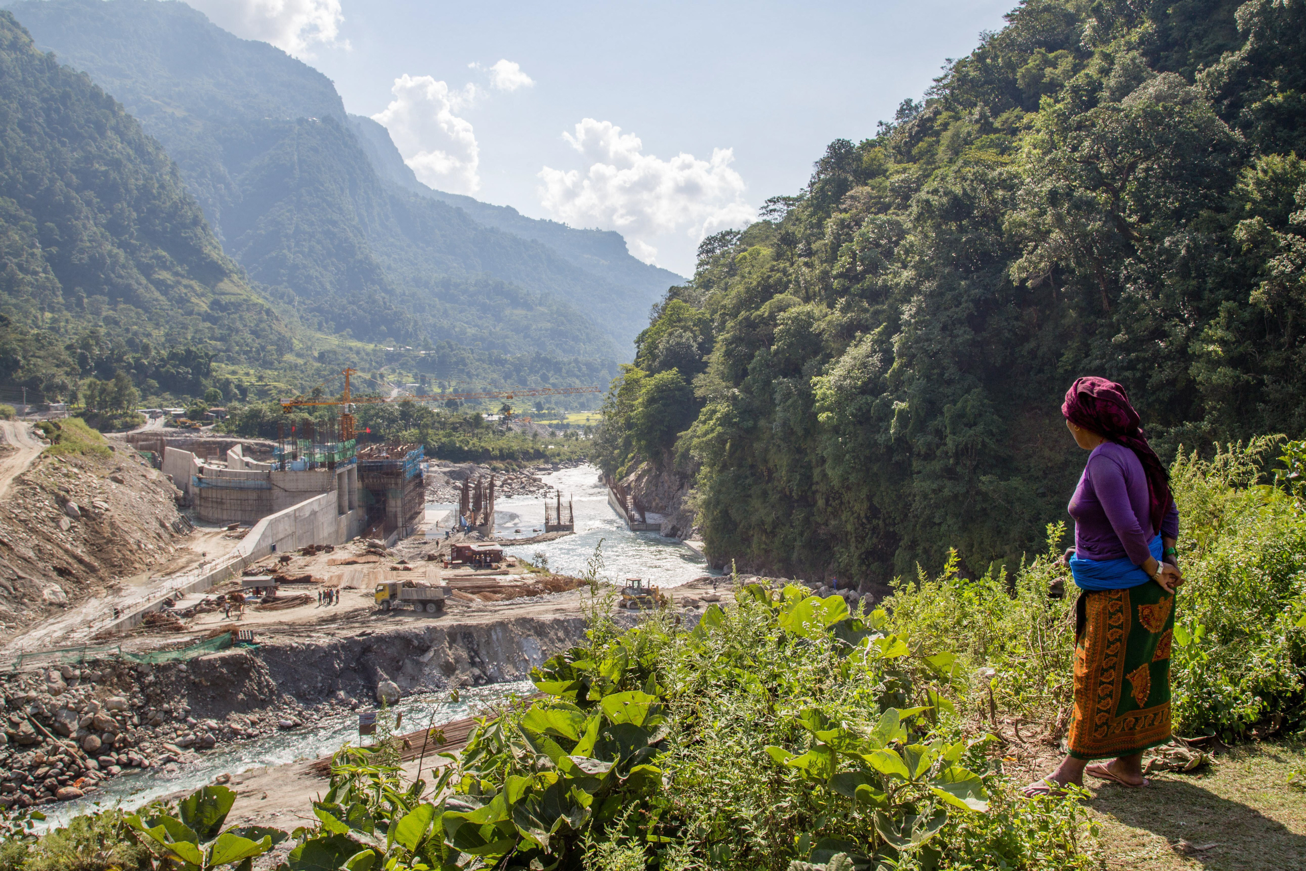 woman looking out over dam construction site