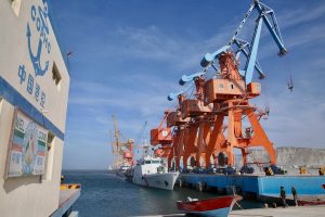 Cargo ships docked at a busy port with cranes