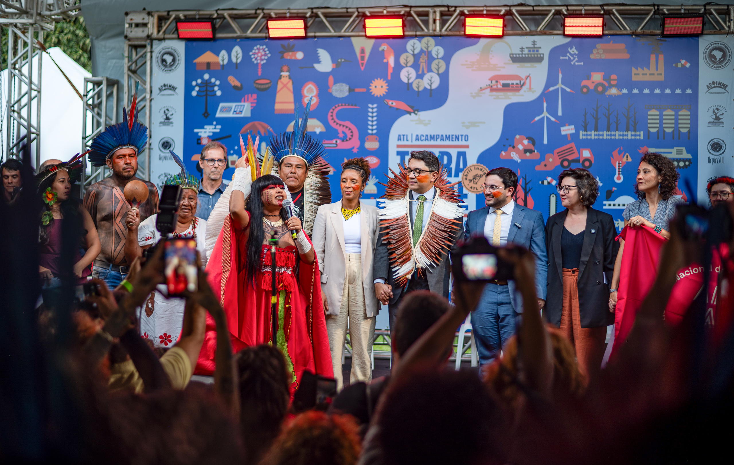 group of people standing on stage in front of cheering crowd