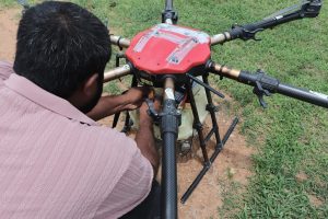 man attaches battery to agricultural drone