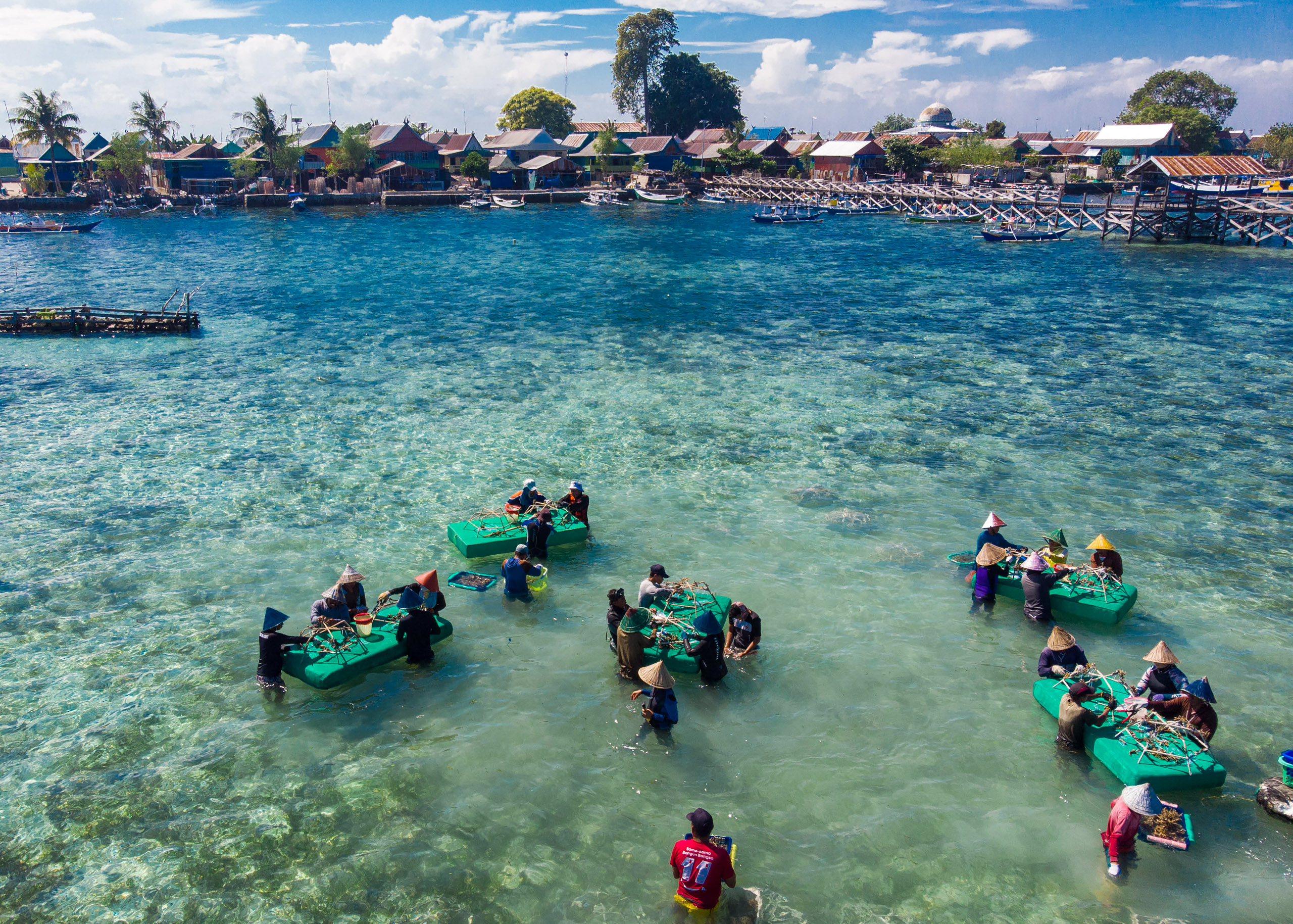 People stand in the sea with platforms in a tropical place