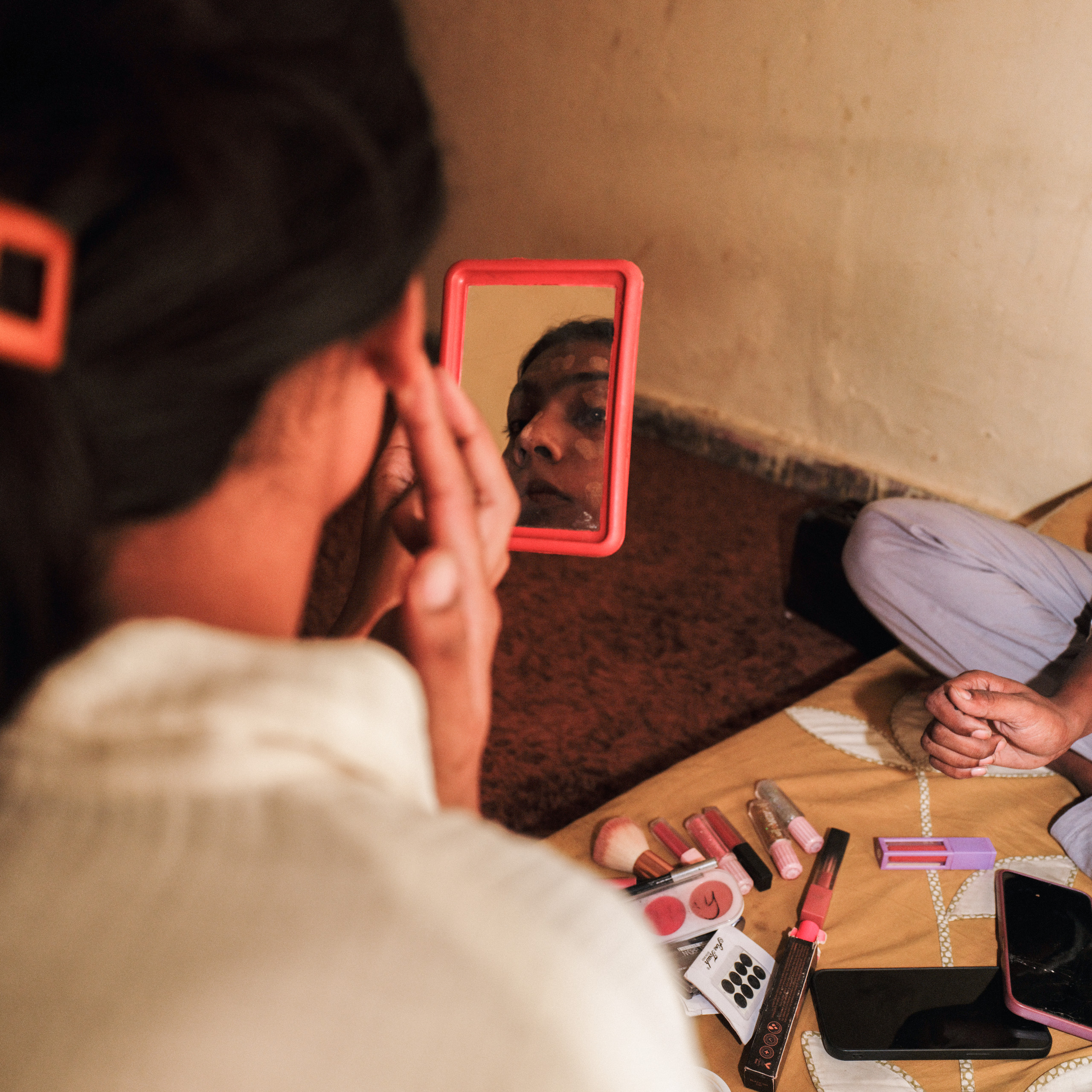 woman looking into small hand mirror