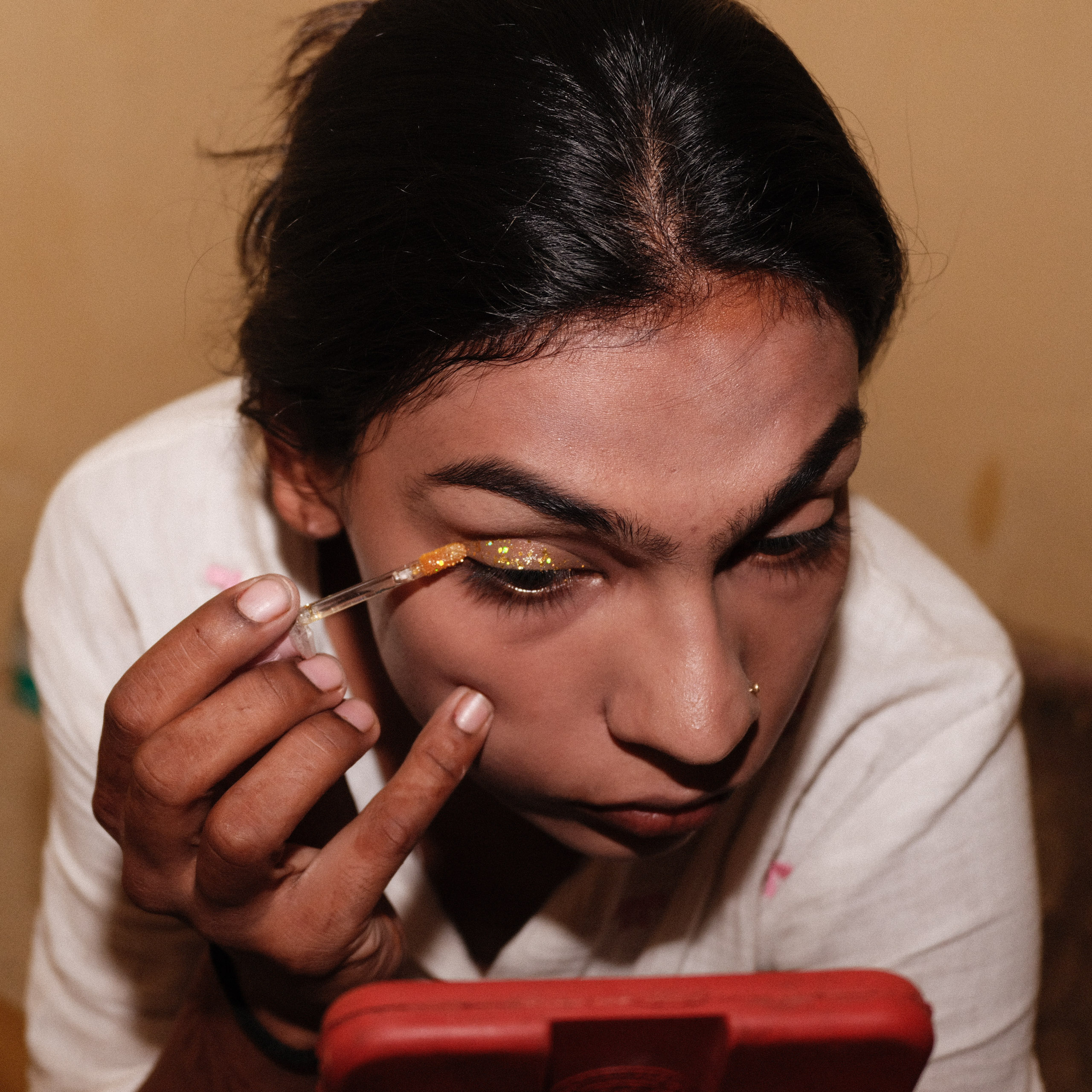 woman applying glitter eye makeup