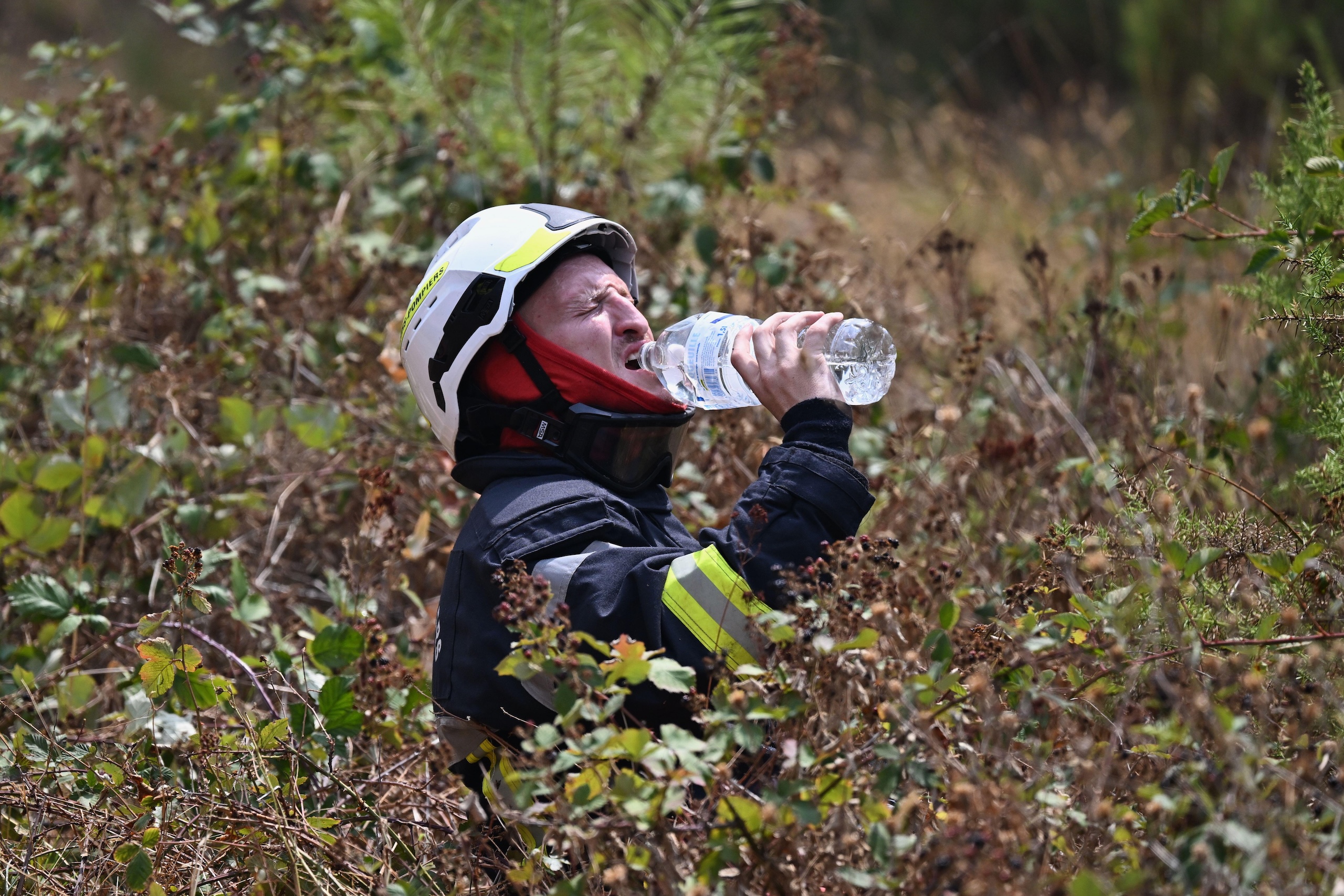 A firefighter takes a drink of water while battling a wildfire 