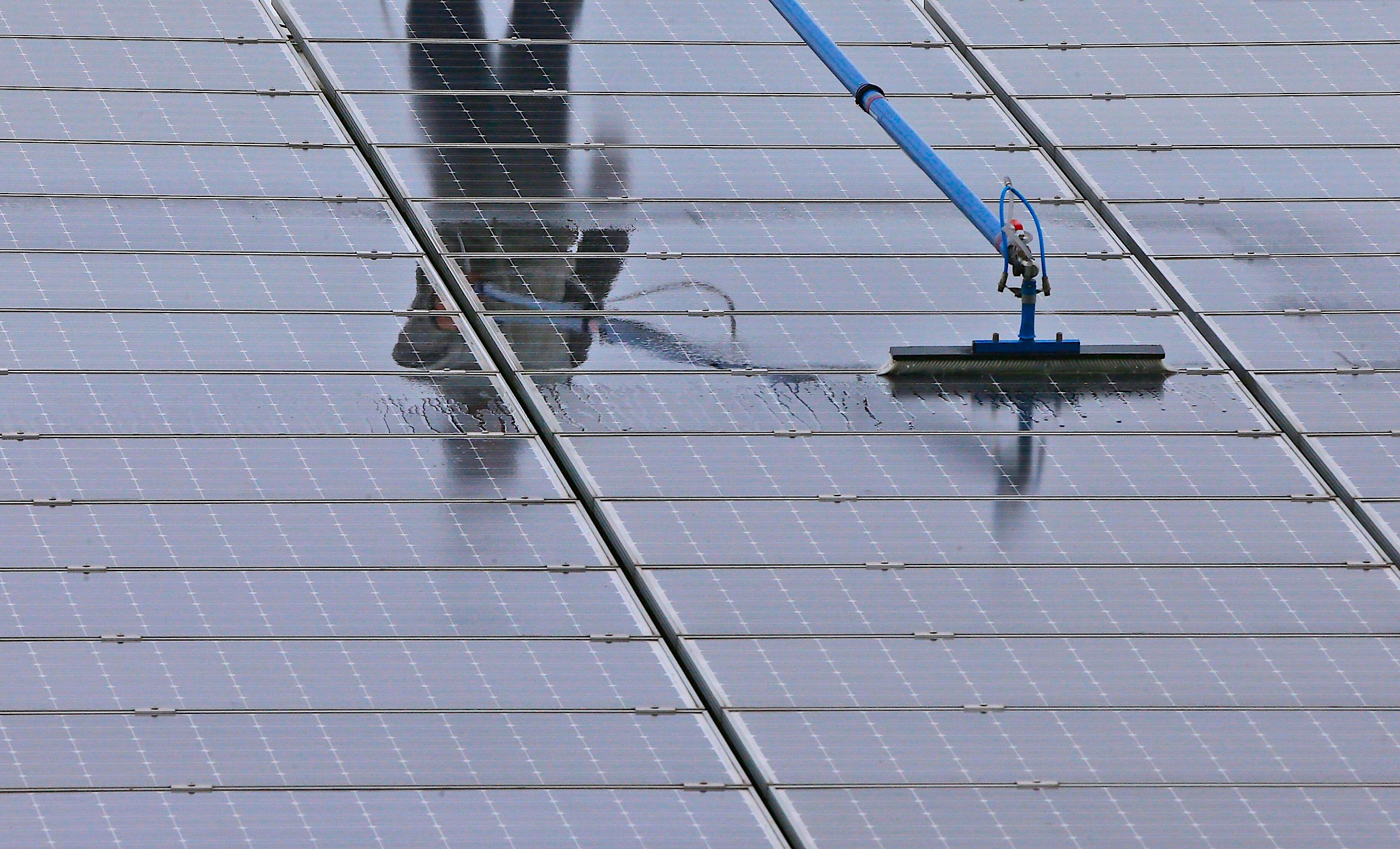 <p>A solar panel cleaner at work in Moers, western Germany (Image: Frank Augstein / Associated Press / Alamy)</p>