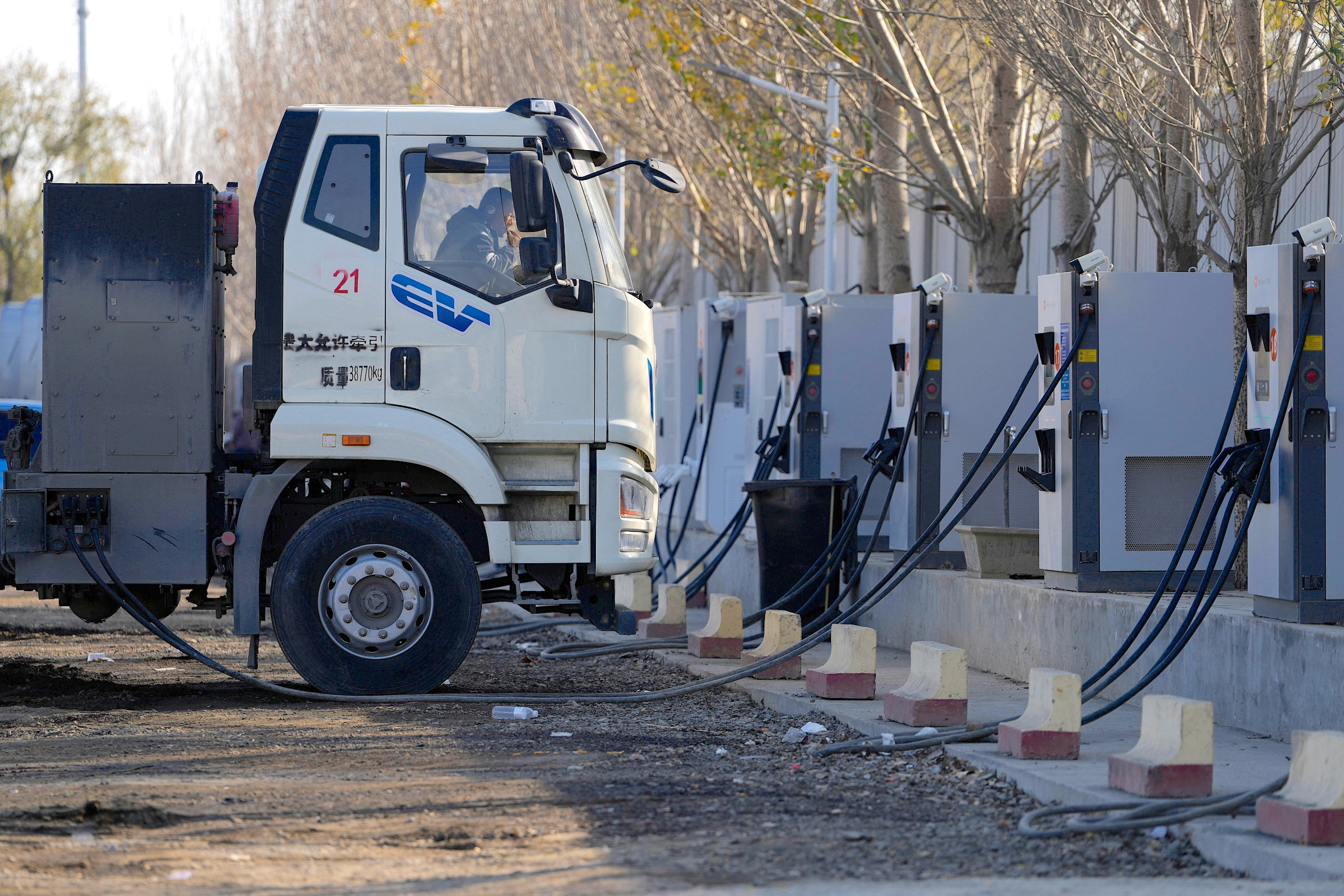 An electric truck charging at a charging station