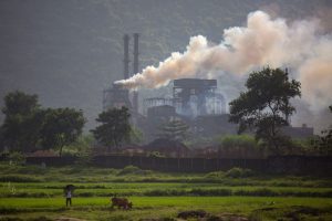 heavy smoke over field from factory