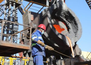 man in protective gear handling molten metal