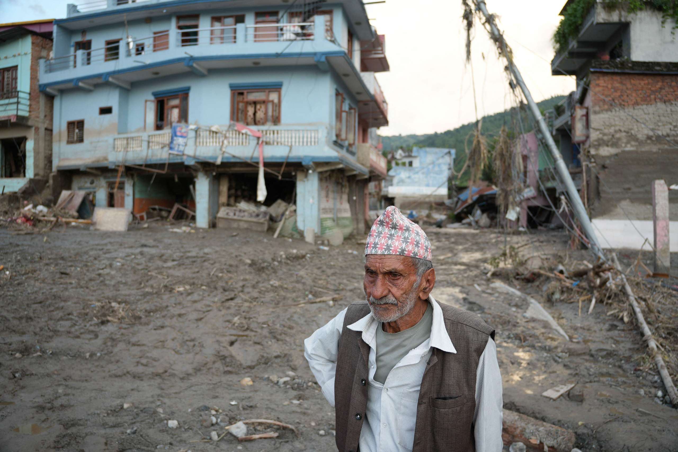 <p>A man surveys damage wrought by flash floods in Devighat, Nepal, on 27 August (Image: Sunil Pradhan / Abaca Press / Alamy)</p>