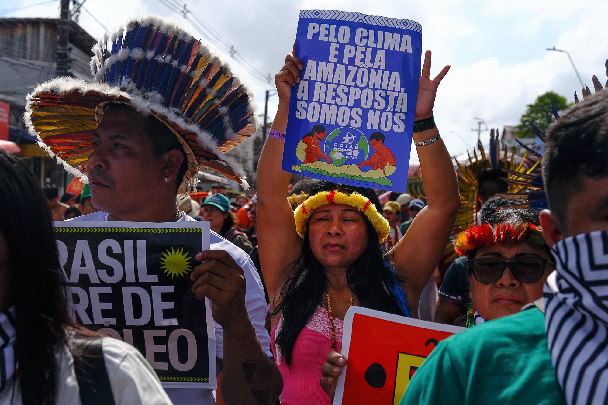 Una mujer indígena sosteninedo un cartel en una marcha
