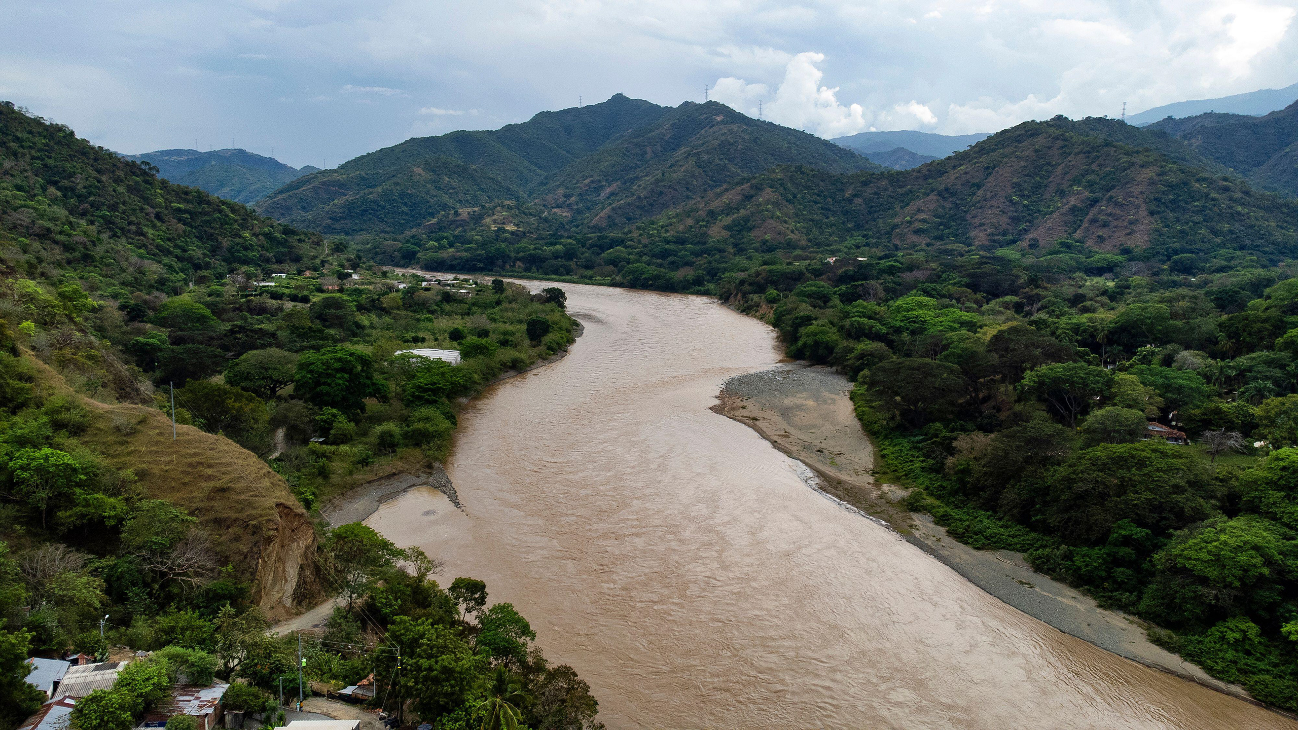 ancho río marrón entre verdes colinas