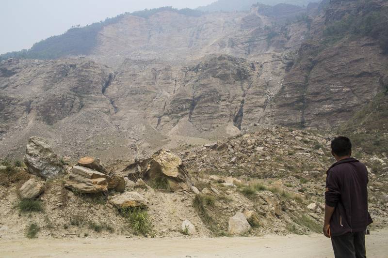 At Sindhupalchowk district in Nepal, a man waits for a bus on the debris of the 2014 Jure landslide on the Bhotekoshi River (Photo by Nabin Baral)