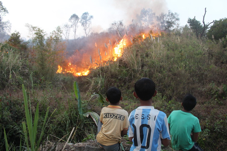The children assigned with firefighting tasks, watch patiently as the fire spreads [image by Mirza Zulfiqur Rahman]