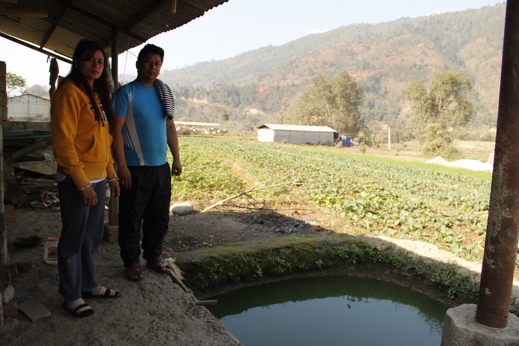 Rajendra Chitrakar and Jiling in Nuwakot stand next to a well that they pump water into next to Trisuli river 